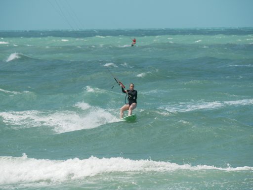 Frau mit Waveboard im Meer, Wellen brechen